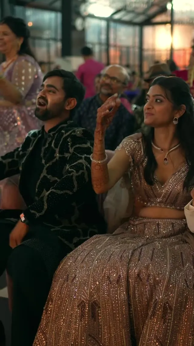 Reception film still of a couple in festive dress at an evening sangeet